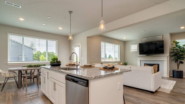 A modern kitchen with a central island, built-in dishwasher, and a dining area with a table and chairs. - Relaxing Getaway w/ Pool Access!

 (Camas)