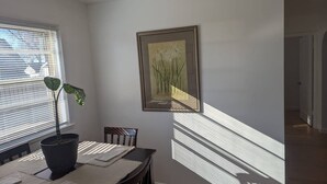 A dining area with a table, chairs, a potted plant, and a framed picture on the wall. - Nestled in the heart of Pierre, shopping & dining near. (Pierre)