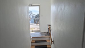A staircase with wooden steps and black risers leading to a door. - Nestled in the heart of Pierre, shopping & dining near. (Pierre)