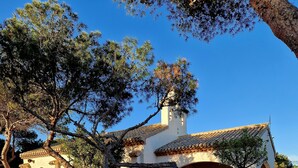 A traditional building with a tiled roof, arched windows, and a white facade. - Caballito del Mar apartment in Punto Prima, Valencia (Punta Prima)