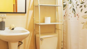 A bathroom with a pedestal sink, toilet, and a metal shelf unit. - Cozy Apartment for 2 w/roof. View to Volcanoes (Panajachel)