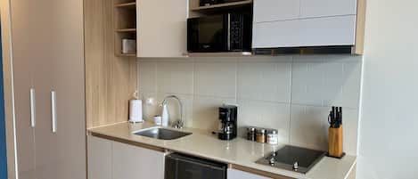 Una cocina moderna con lavavajillas, cafetera y microondas.