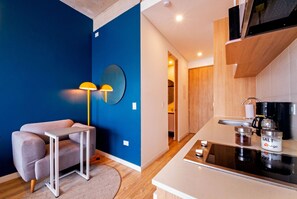 A modern kitchen with a built-in stove, a coffee maker, and a salt container on the counter. - U-GO Edificio Next Living Bogota (Bogotá)