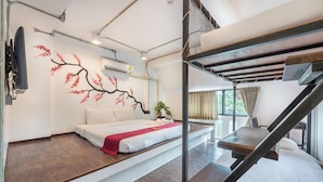 Ein modernes Hotelzimmer mit einem Bett, einer roten Wand, einer Treppe und einem Fenster mit Vorhängen.