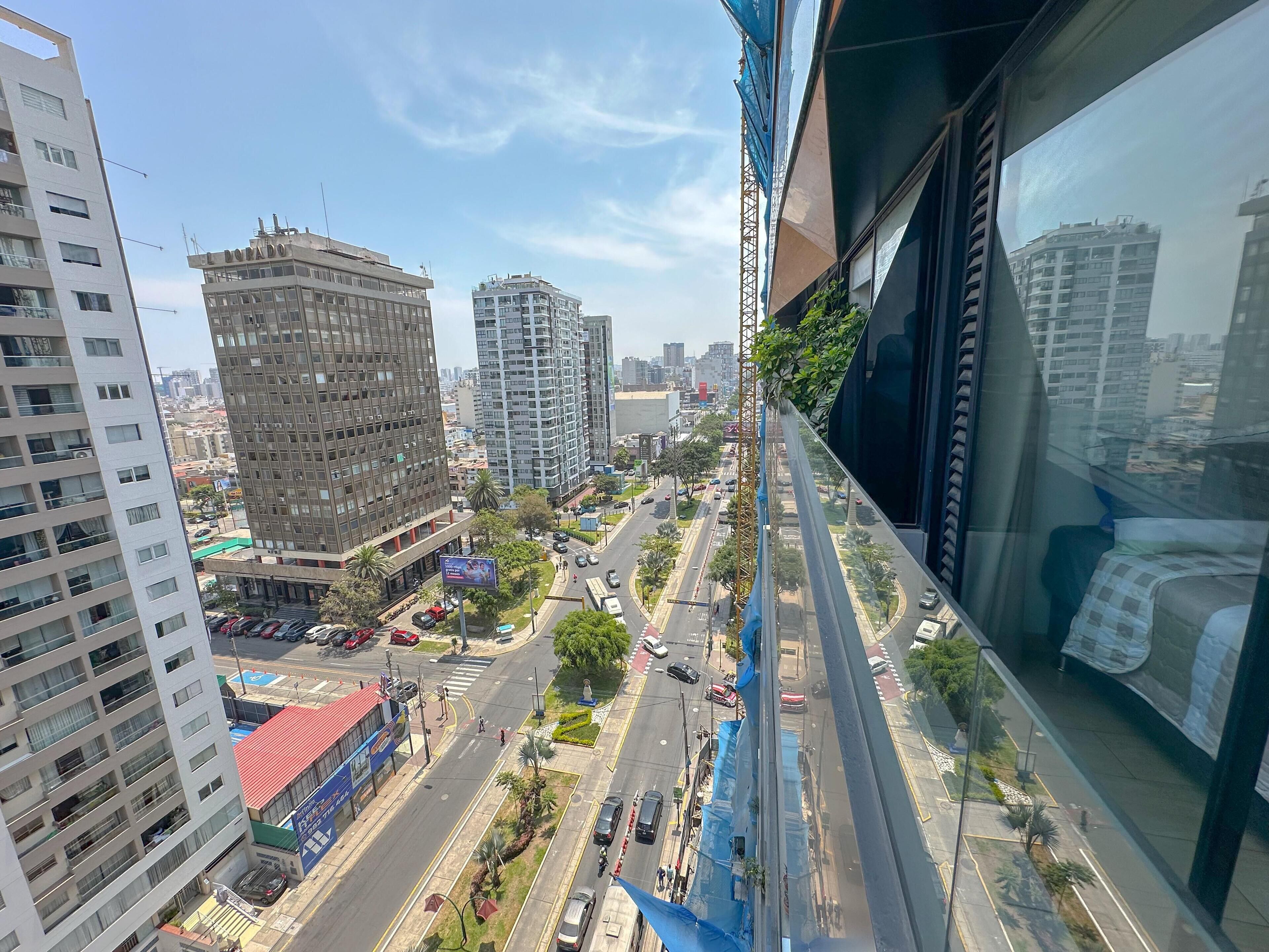 A high-rise building with multiple floors, large windows, and a view of a busy street with cars and pedestrians.