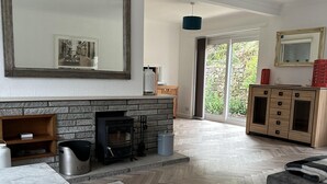 Un salon avec une cheminée, une table à manger, un canapé et un grand miroir.