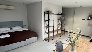 A modern bedroom with a bed, a wooden dining table, and a decorative vase. - Digital Nomad House (Istanbul)
