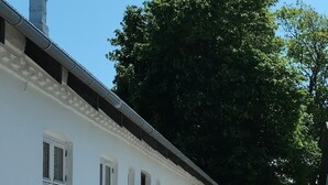 Un edificio blanco con varias ventanas y un camino de entrada de grava.