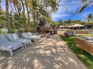 Relax in a serene outdoor lounge surrounded by lush greenery and tropical plants.