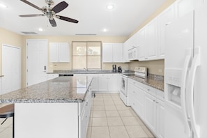Enjoy cooking in this well-lit kitchen with a large island and microwave.