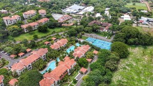 An aerial view of a resort with multiple buildings, a swimming pool, and lush greenery. - Tuscan-style 3 bed Villa with private pool (Playas del Coco)