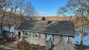 A house with a wooden deck and a small staircase leading to the front door. - Lakefront Connecticut Oasis - Updates throughout  (Oxford)