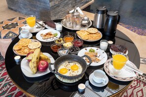 A breakfast table with various dishes, including eggs, toast, and fruit.
