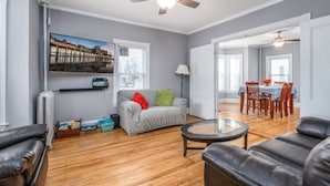 A living room with a grey sofa, a coffee table, and a dining area with a table and chairs.