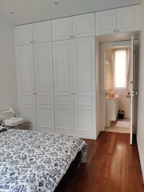 A bedroom with a bed, a wardrobe, and a bathroom visible through an open door. - Eiffel Dream (30 mètres de la Tour Eiffel) (Paris)