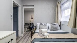 A hotel room with a bed, a desk, and a chair. - Modern studio near Wembley #2 (Harrow)