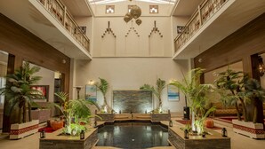 A spacious lobby with a central water feature, high ceilings, and decorative lighting. - Riad kenza (Marrakech)