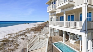 A beachfront property with a pool, multiple balconies, and a beach view. - Beach House - Anchors Aweigh by PHG (Panama City Beach)