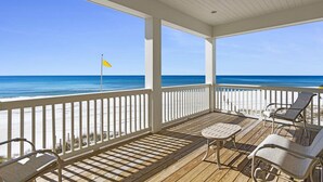 A covered deck with a view of the beach, white railings, and two lounge chairs. - Beach House - Anchors Aweigh by PHG (Panama City Beach)