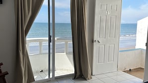 Ein Zimmer mit Bett, Blick auf den Strand und einer Tür mit der Aufschrift '31'.