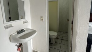 Ein Badezimmer mit Waschbecken, Spiegel und Toilette.
