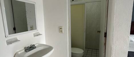 Ein Badezimmer mit Waschbecken, Spiegel und Toilette.