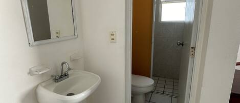 Ein Badezimmer mit Waschbecken, Spiegel und Toilette.
