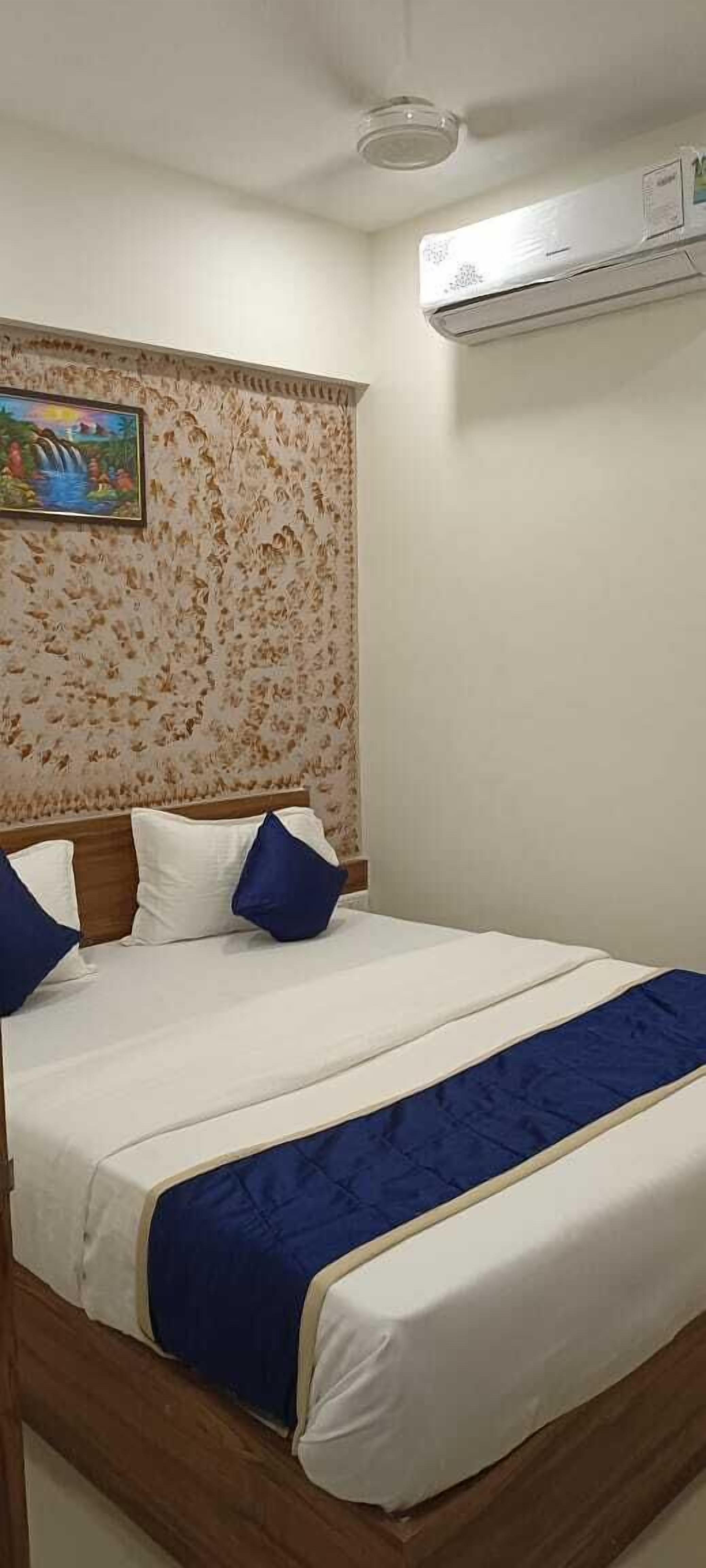 Un dormitorio con cama, cabecera, aire acondicionado de pared y un cuadro enmarcado.