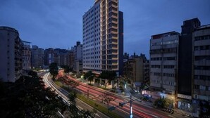 A high-rise building with a modern design, surrounded by other buildings and a busy street with light trails. - Boutech Jiantan Hotel (Taipei)