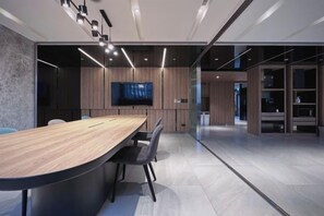 A modern conference room with a long table, chairs, a flat-screen TV, and a glass partition. - Boutech Jiantan Hotel (Taipei)