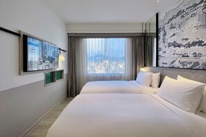 A hotel room with a large bed, a city view, a mounted TV, and a modern wall art piece.