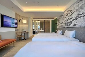 A hotel room with a TV, two beds, a desk, and a large painting on the wall. - Boutech Jiantan Hotel (Taipei)