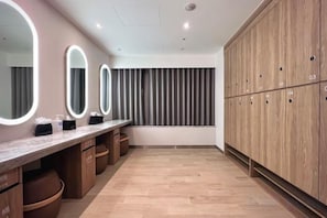 A modern bathroom with a vanity, mirrors, and wooden cabinets.