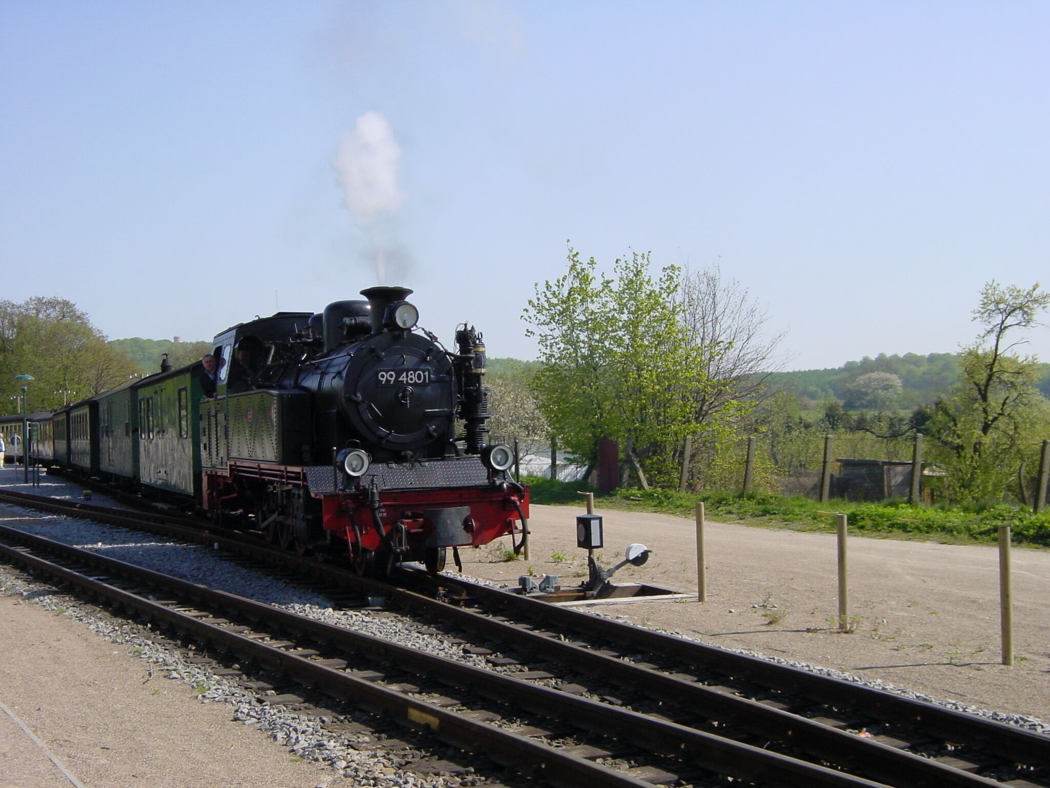 A steam locomotive with the number 99 4801 on a railway track.
