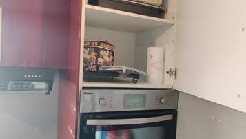 Una cocina compacta con horno integrado y microondas.