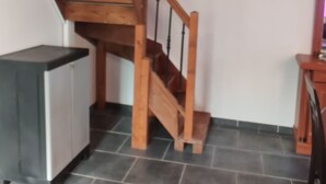 Portaat, joissa on puiset askelmat ja kaide, johtavat ylempään kerrokseen.