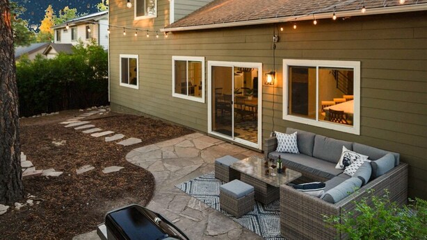 A patio area with a grill, outdoor seating, and a view of the night sky. - Designer Home with Chef's kitchen, Walking Trails (Flagstaff)