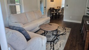 Un salon comprenant un canapé, une table basse et un coin repas avec une table et des chaises.