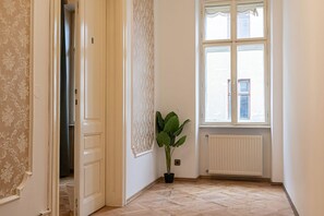 A corner room with a large window, a radiator, and a potted plant.