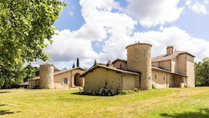 Un bâtiment traditionnel en pierre, doté de plusieurs arcades et d’une cour intérieure.