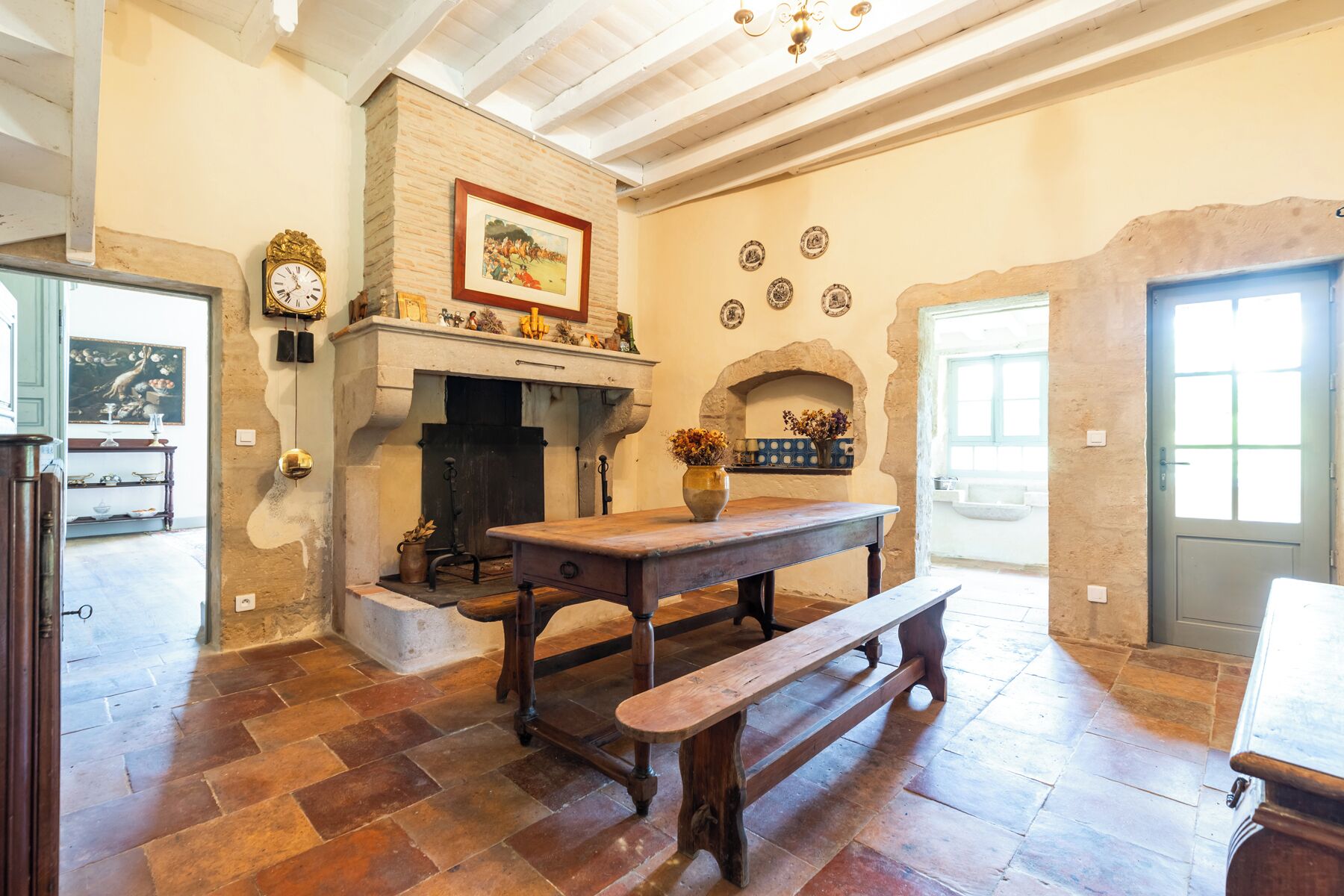 Un intérieur rustique avec une cheminée, des murs en pierre et un banc en bois.