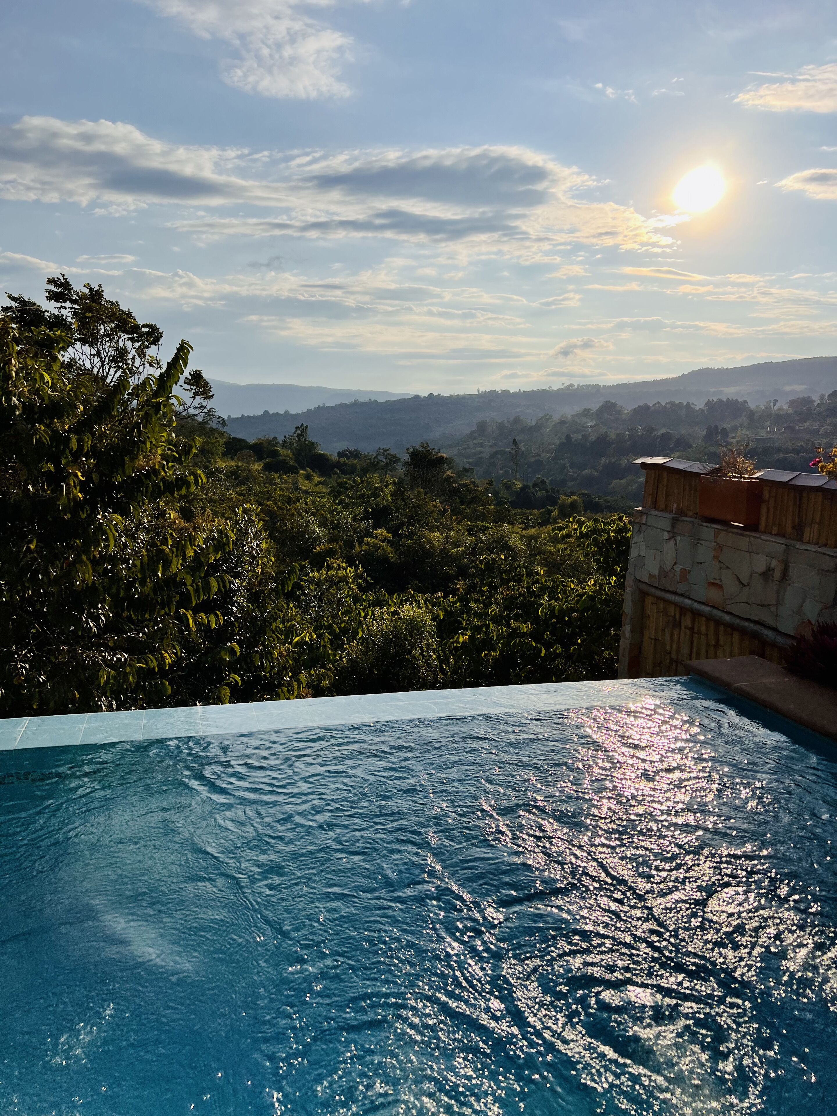 An infinity pool with a view of a mountainous landscape and a clear sky.