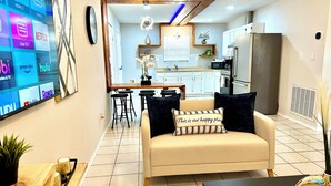 Een moderne woonkamer met een bank, een salontafel en een tv waarop streamingdiensten worden getoond.