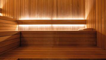 A wooden sauna with benches and a sloped ceiling.