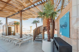 Una piscina techada, una piscina al aire libre, sombrillas