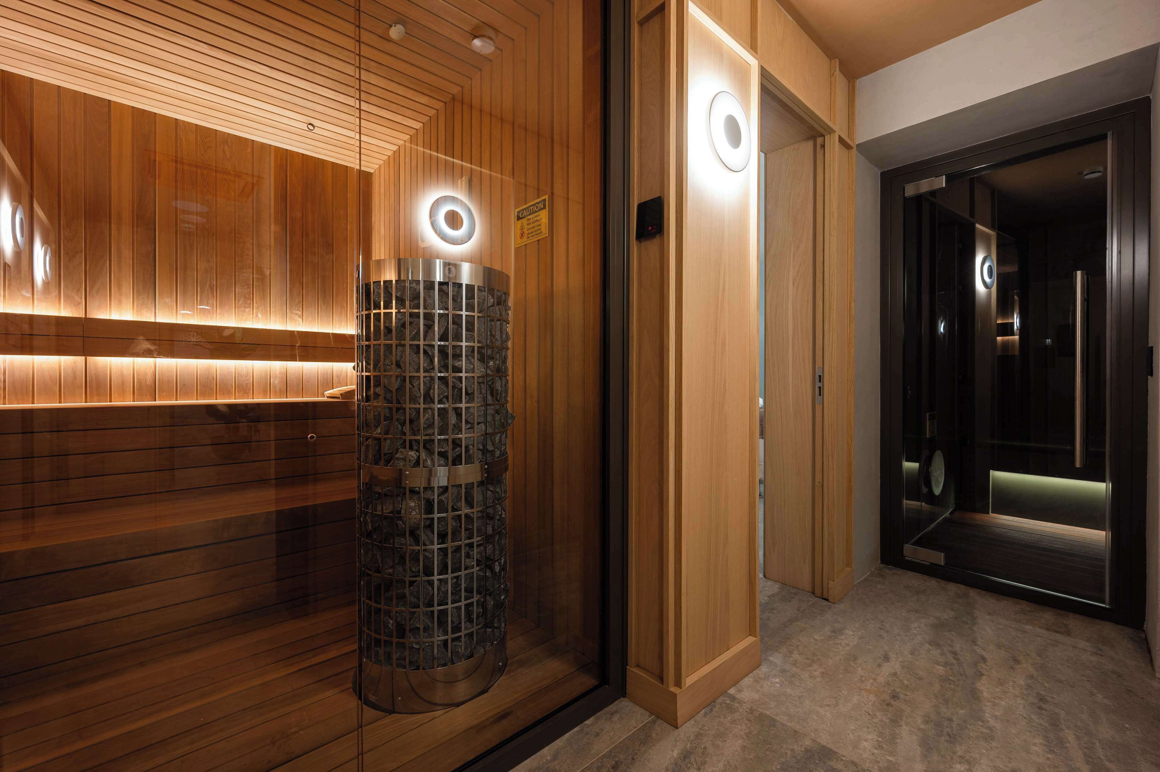 A modern elevator with a circular light fixture and a wooden panel wall.