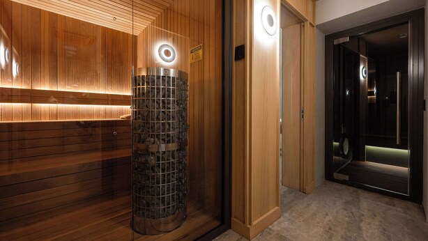 A modern elevator with a circular light fixture and a wooden panel wall. - Best Western Premier Malta (St. Paul's Bay)