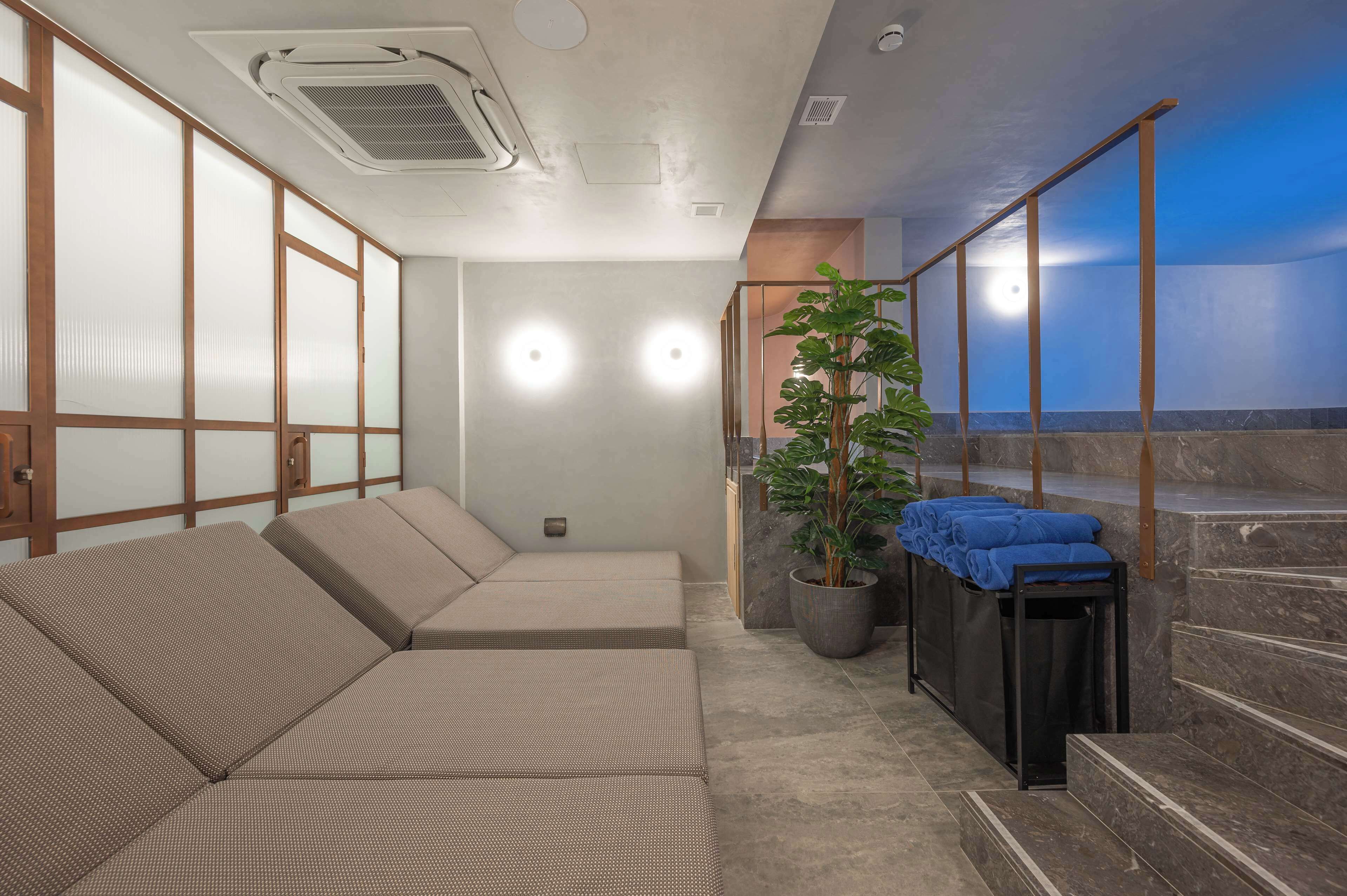 Ein Wellnessbereich mit Sitzgelegenheit, einem Blumentopf und einer Treppe.