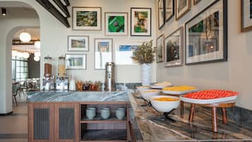 A buffet area with various food items and a marble countertop.
