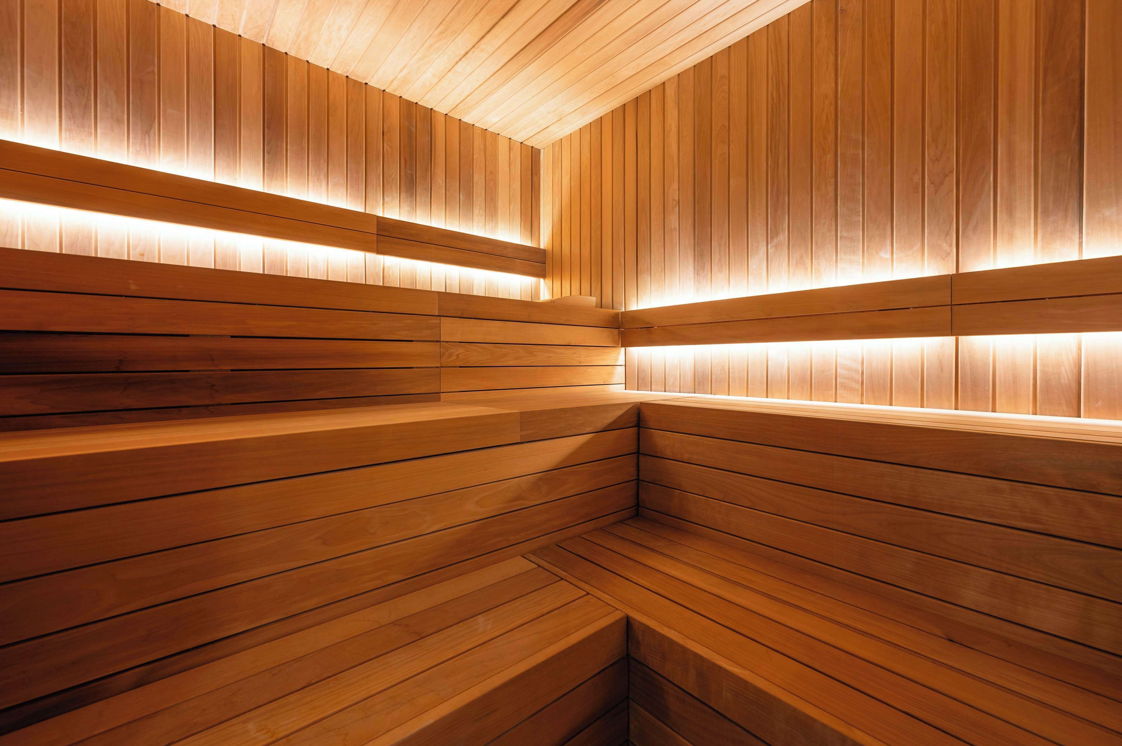 A wooden sauna with slatted walls and benches.